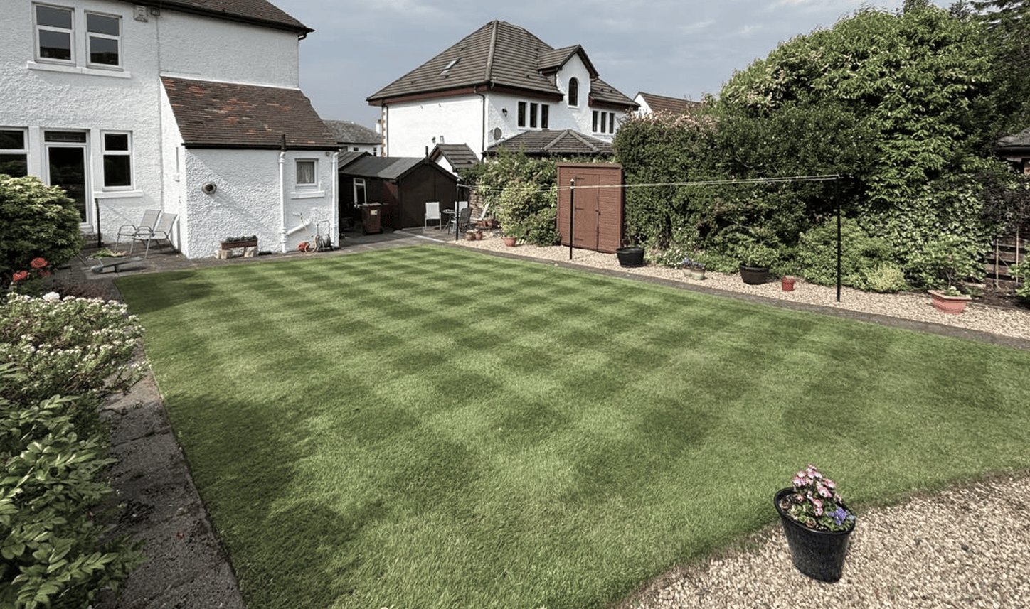 background image of a beautiful Scottish suburban home's garden in the old style of white stone with beautiful cut striped garden
