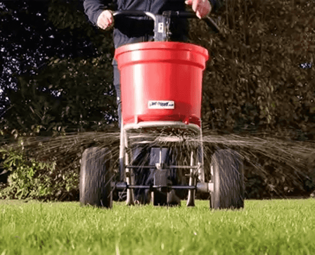 This is the image of a machine that sprays the garden seeds out to the left and right as the gardener moves up and down the lawn
